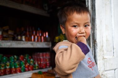FALAM, MYANMAR - JUNE 17 2015: Local cute boy stands at convenience store entrance at the start of the monsoon season in the recently opened to tourists Chin State region of Western Myanmar (Burma)