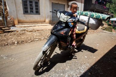 CHIN STATE, MYANMAR - JUNE 18 2015: Young boy on motorbike in the recently opened for tourists Chin State Mountainous Region, Myanmar (Burma)