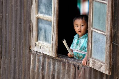 CHIN STATE, MYANMAR - JUNE 18 2015: Cute young boy in window in the recently opened for tourists Chin State Mountainous Region, Myanmar (Burma)