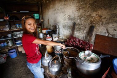 CHIN STATE, MYANMAR - JUNE 18 2015: Cute girl cooks traditional food in the recently opened for tourists Chin State Mountainous Region, Myanmar (Burma)
