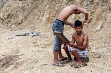 FALAM, MYANMAR - JUNE 17 2015: Local young men cut hair in the recently opened to foreigners area of Chin State - western Myanmar (Burma)