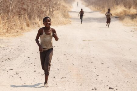CHOBE, BOTSWANA - OCTOBER 5 2013: Poor African children wander through the desert like Chobe National Park. This year was declared as a drought year by the government in Botswana, Africa