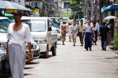 YANGON, MYANMAR - JUNE 12 2015: Local people walking on one of the hottest recorded days before monsoon season in Yangon, Myanmar.