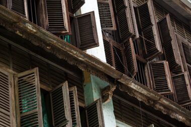 YANGON, MYANMAR - JUNE 12 2015: Rustic wooden window shutters open on one of the hottest recorded days before monsoon season in Yangon, Myanmar.